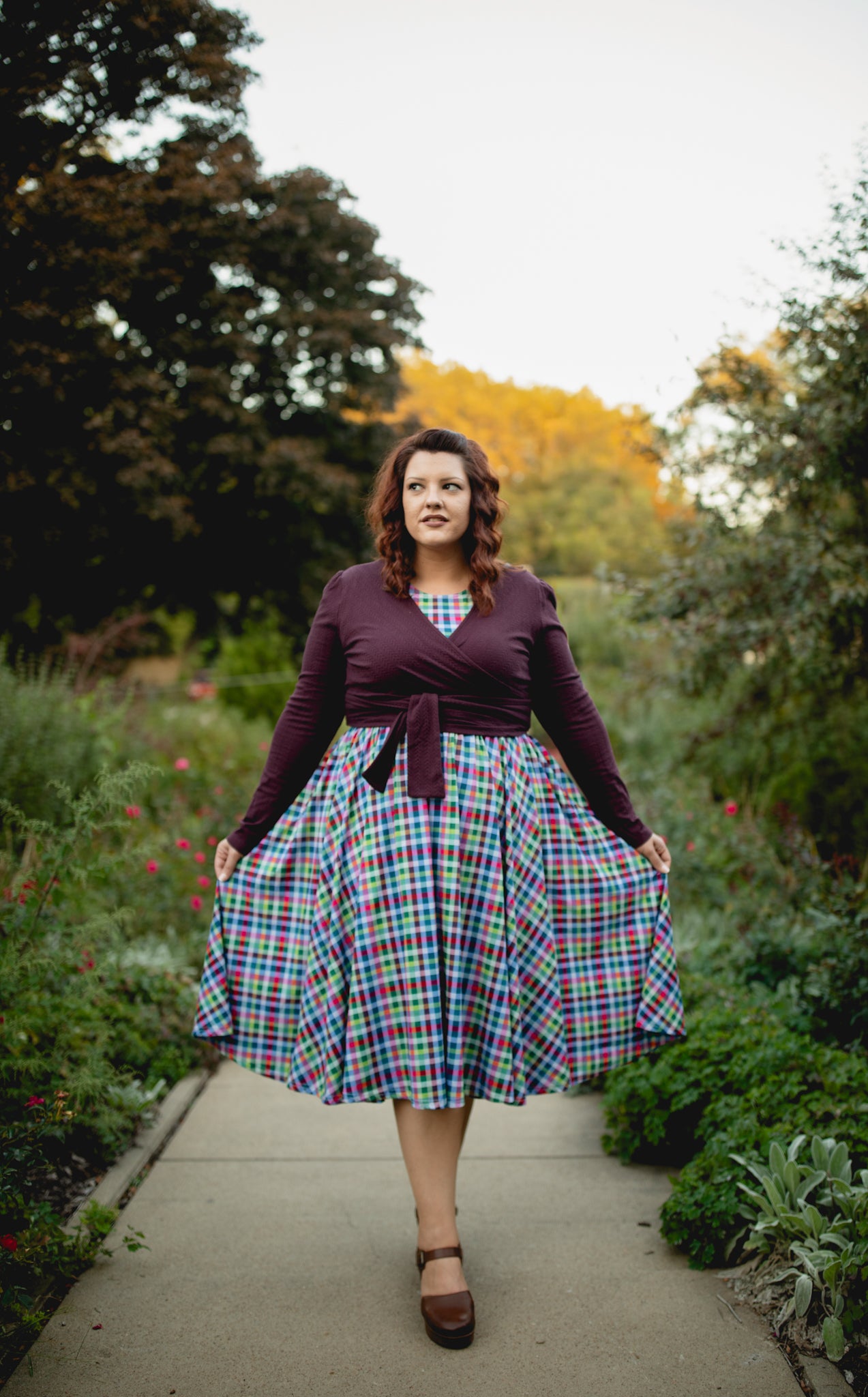 Woman in modest nursing wrap over plaid dress