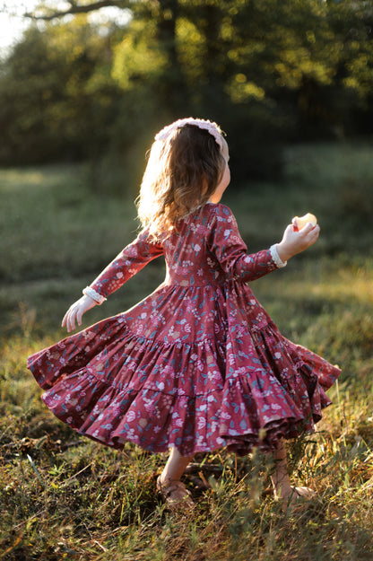 Girl in modest red floral dress twirling outdoors