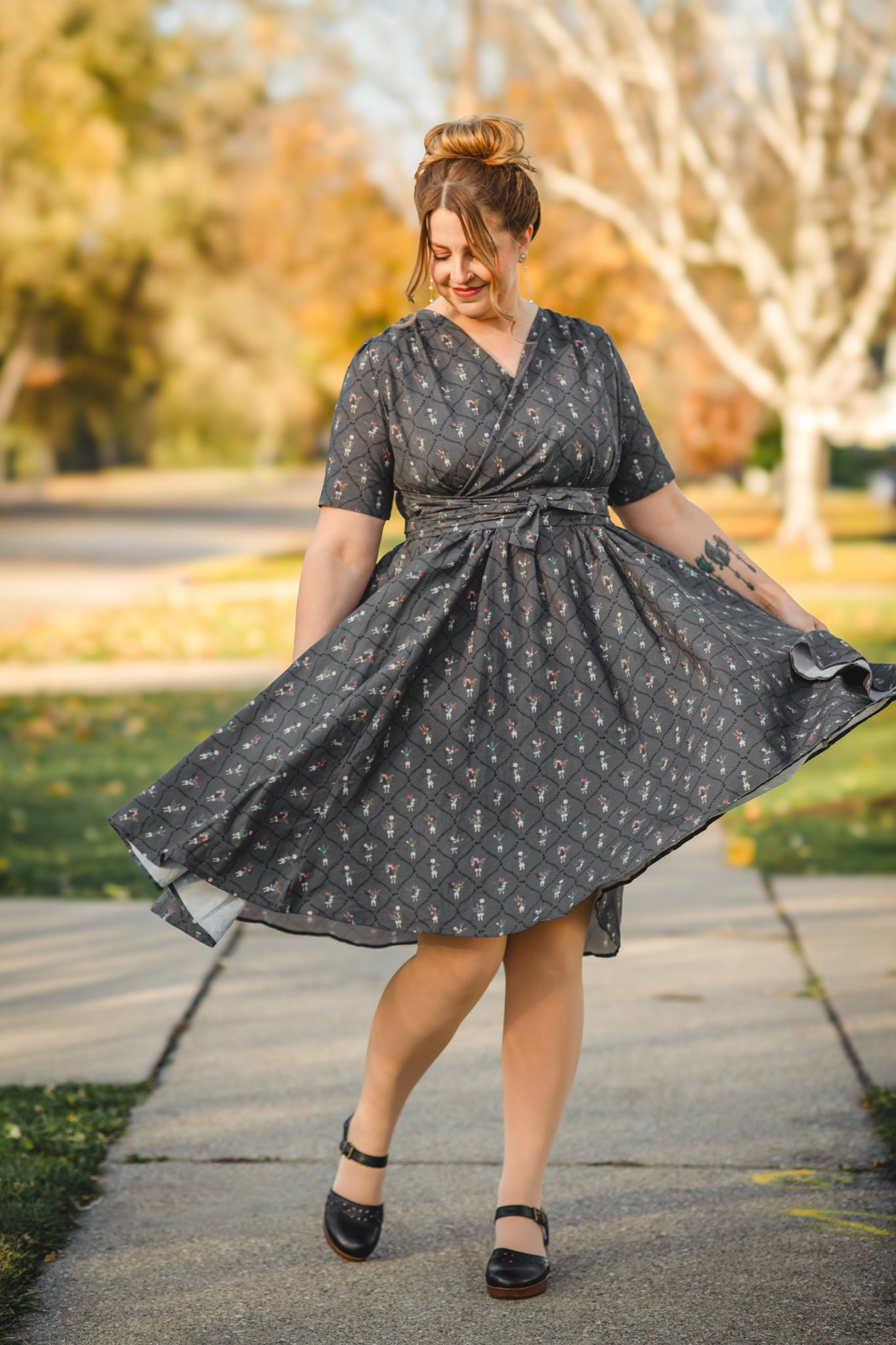 Modest nursing-friendly black patterned dress twirling