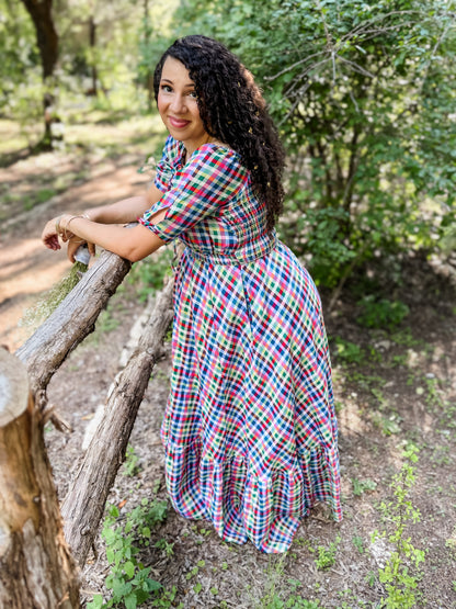 Woman in a colorful modest nursing dress standing outdoors near trees