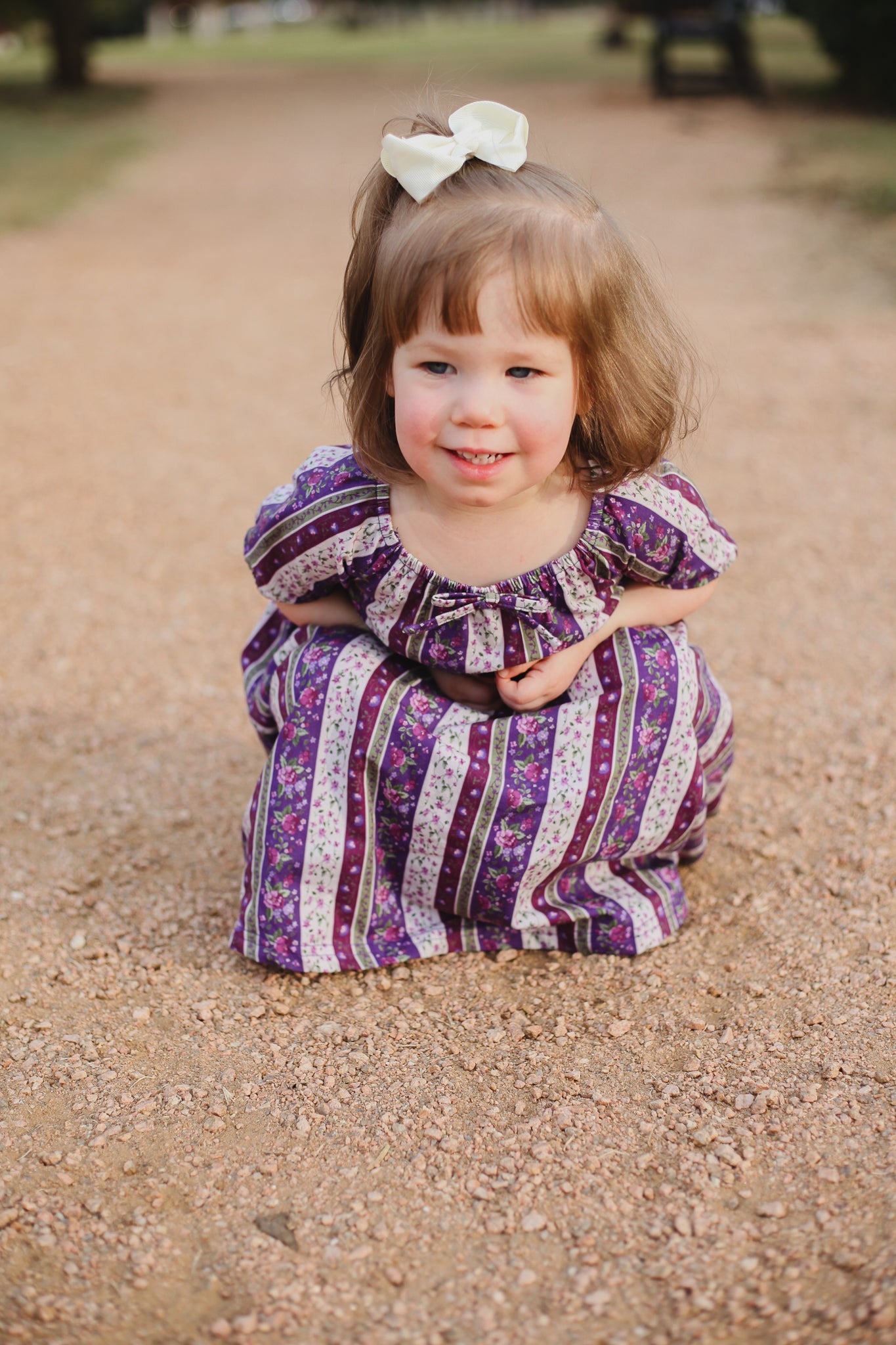 Young girl in modest purple dress with bow