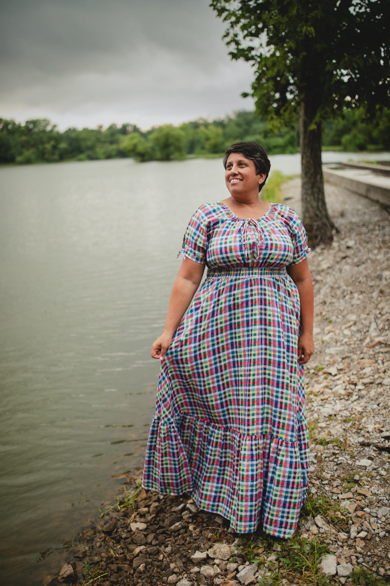 Woman in a plaid modest nursing dress standing by a lake