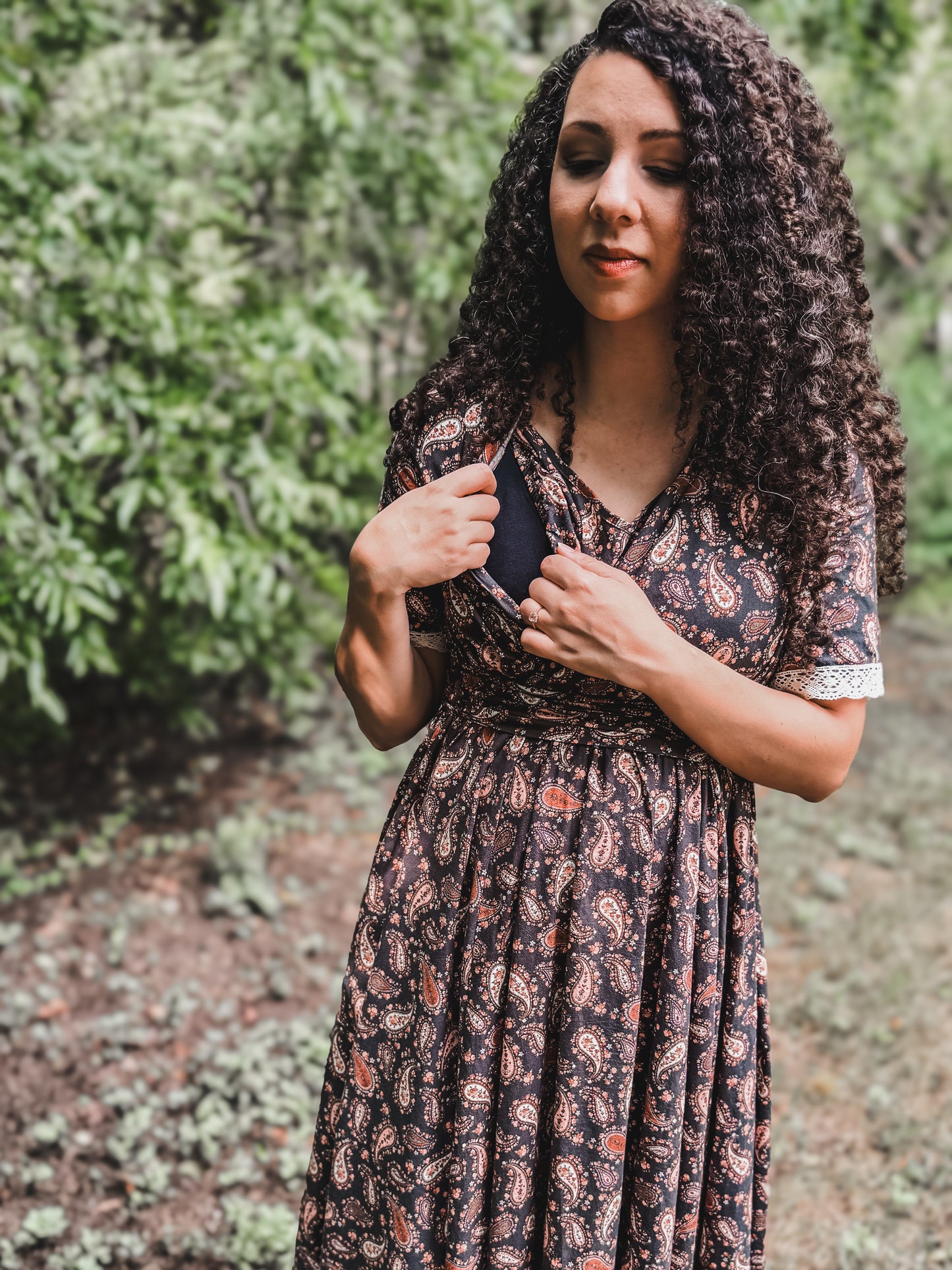 Woman in modest nursing dress among greenery