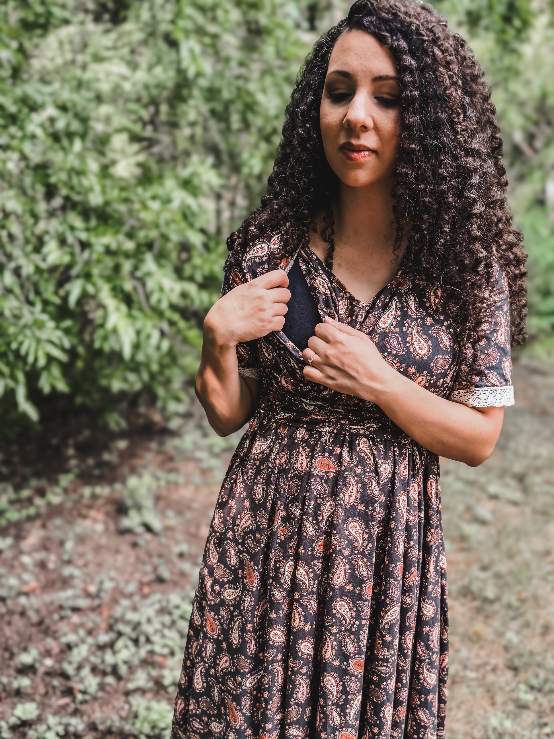 Woman in modest nursing dress among greenery