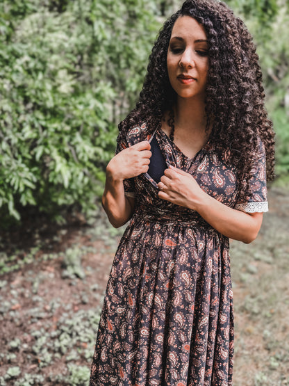 Woman in modest nursing dress among greenery