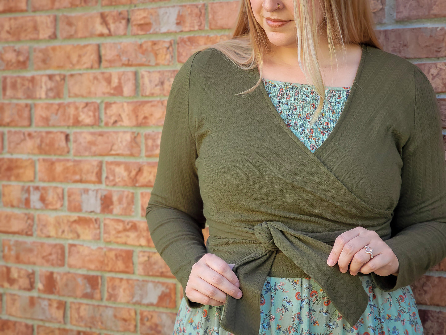 Woman in modest nursing wrap over floral dress