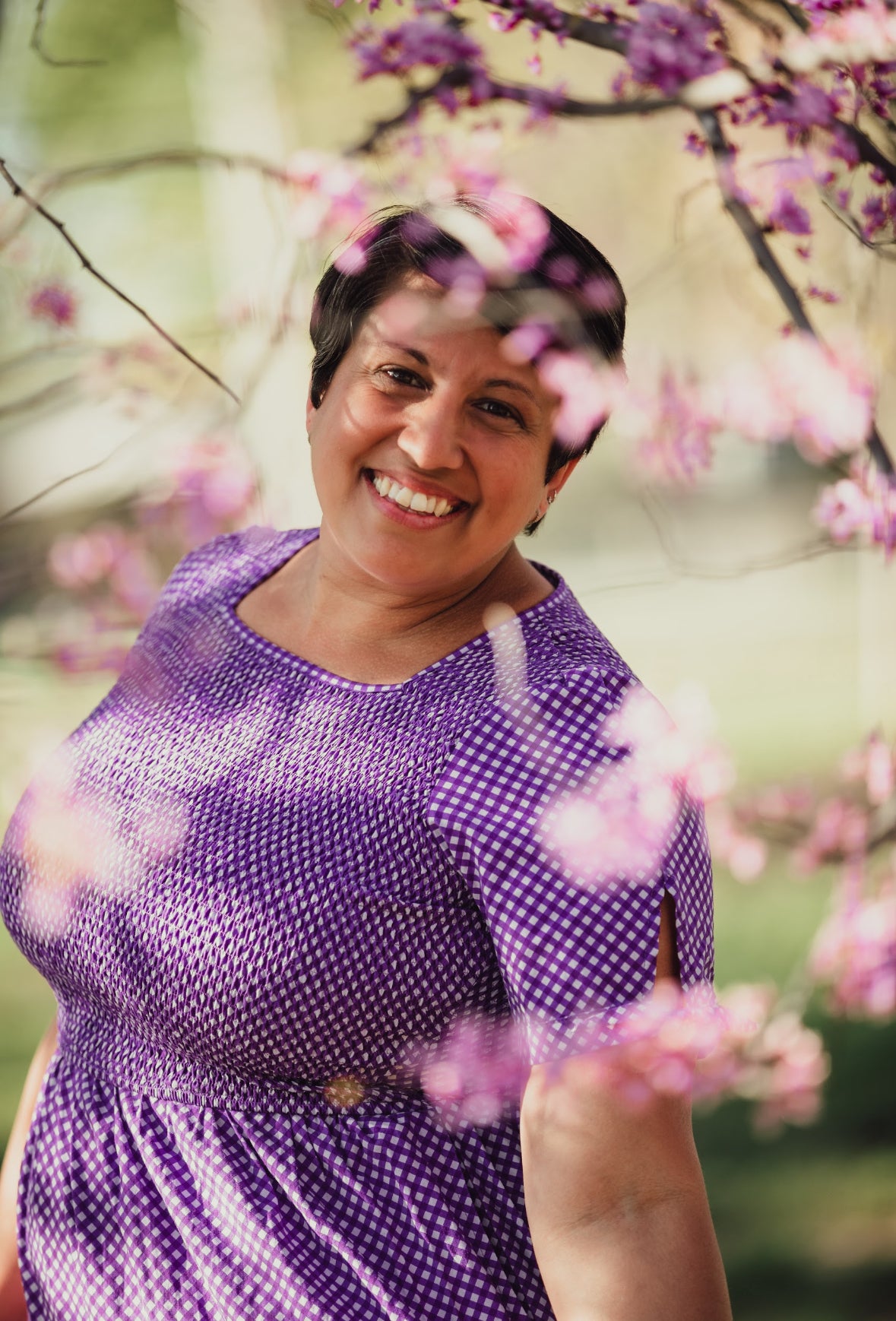 A woman wearing a purple, gingham, five-tiered maxi modest nursing dress