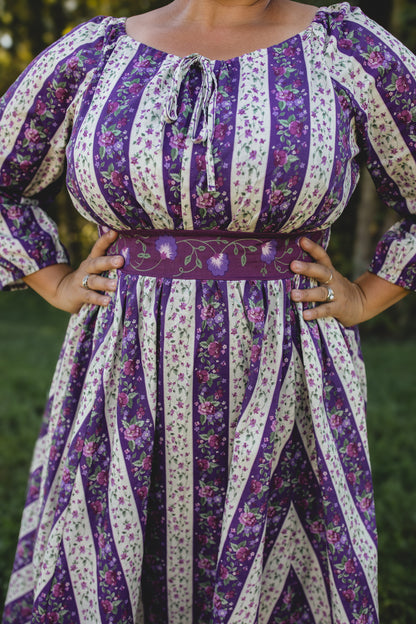 Modest nursing woman wearing purple floral dress outdoors