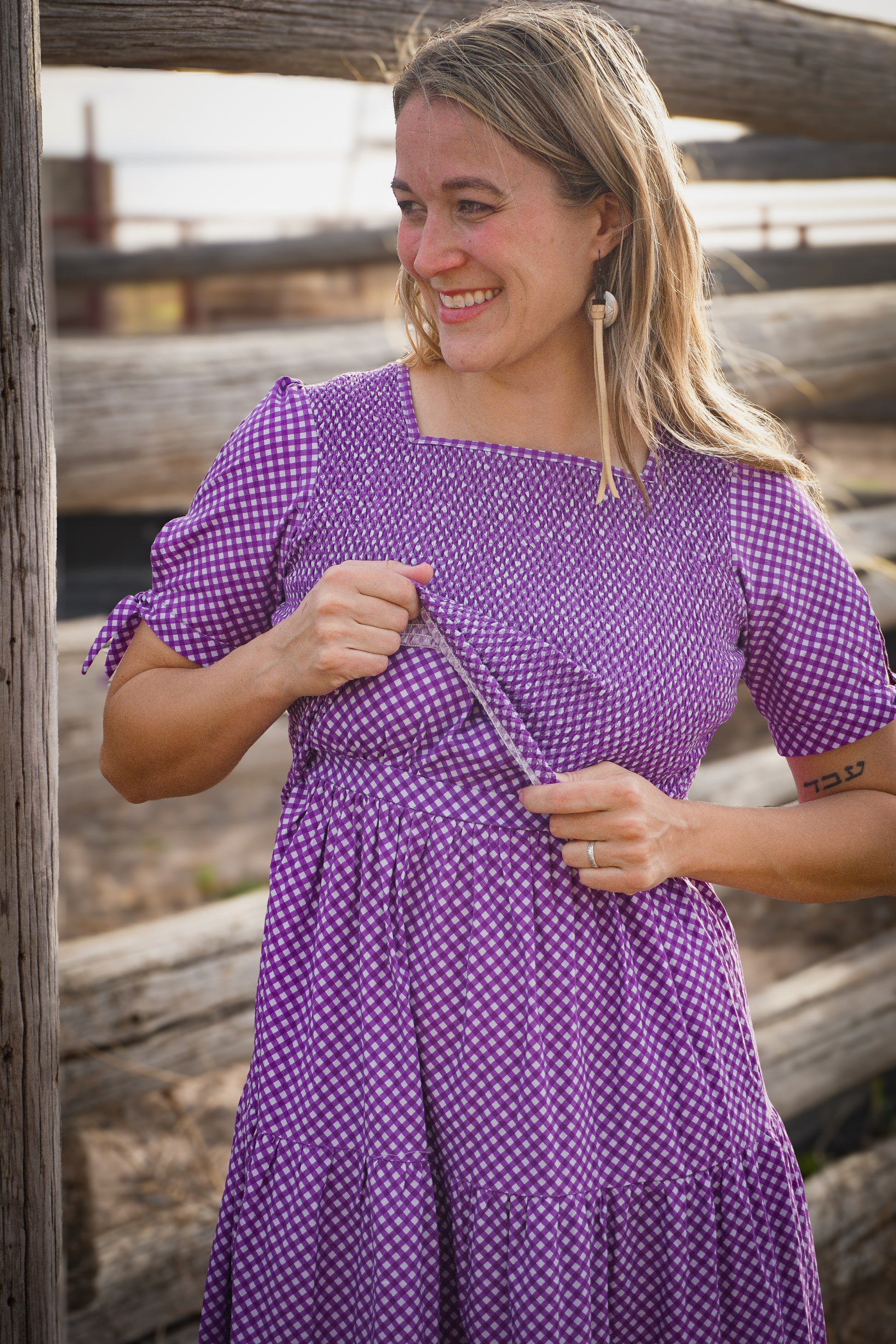A woman wearing a purple, gingham, five-tiered maxi modest nursing dress