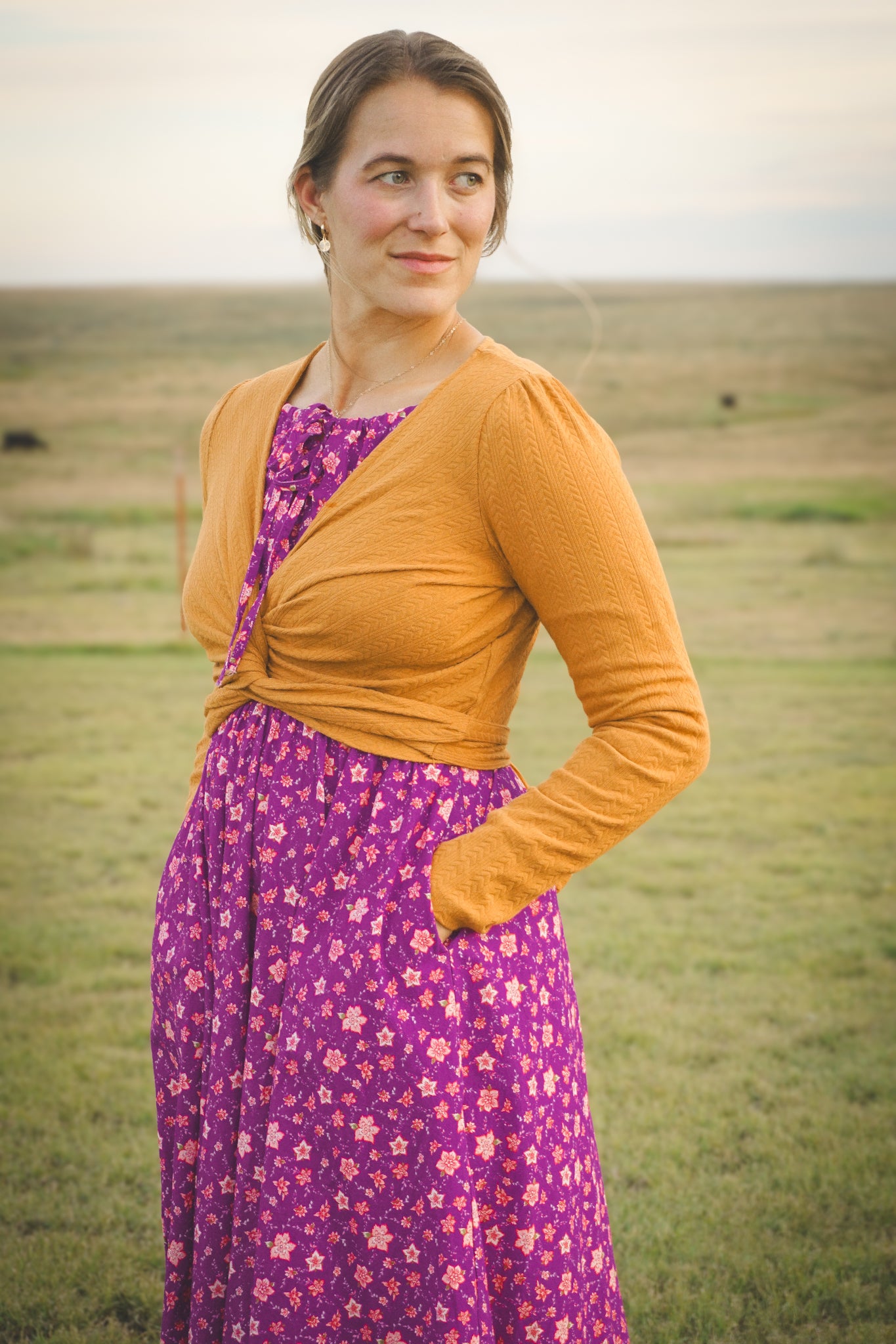 Woman in modest nursing wrap over floral dress
