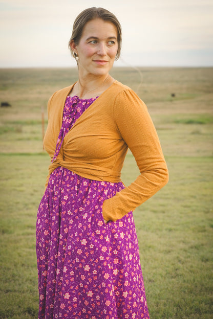 Woman in modest nursing wrap over floral dress