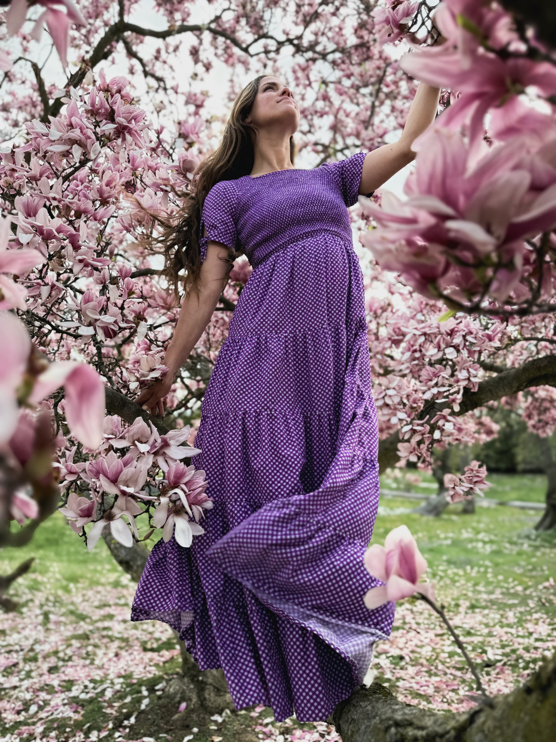 A woman wearing a purple, gingham, five-tiered maxi modest nursing dress