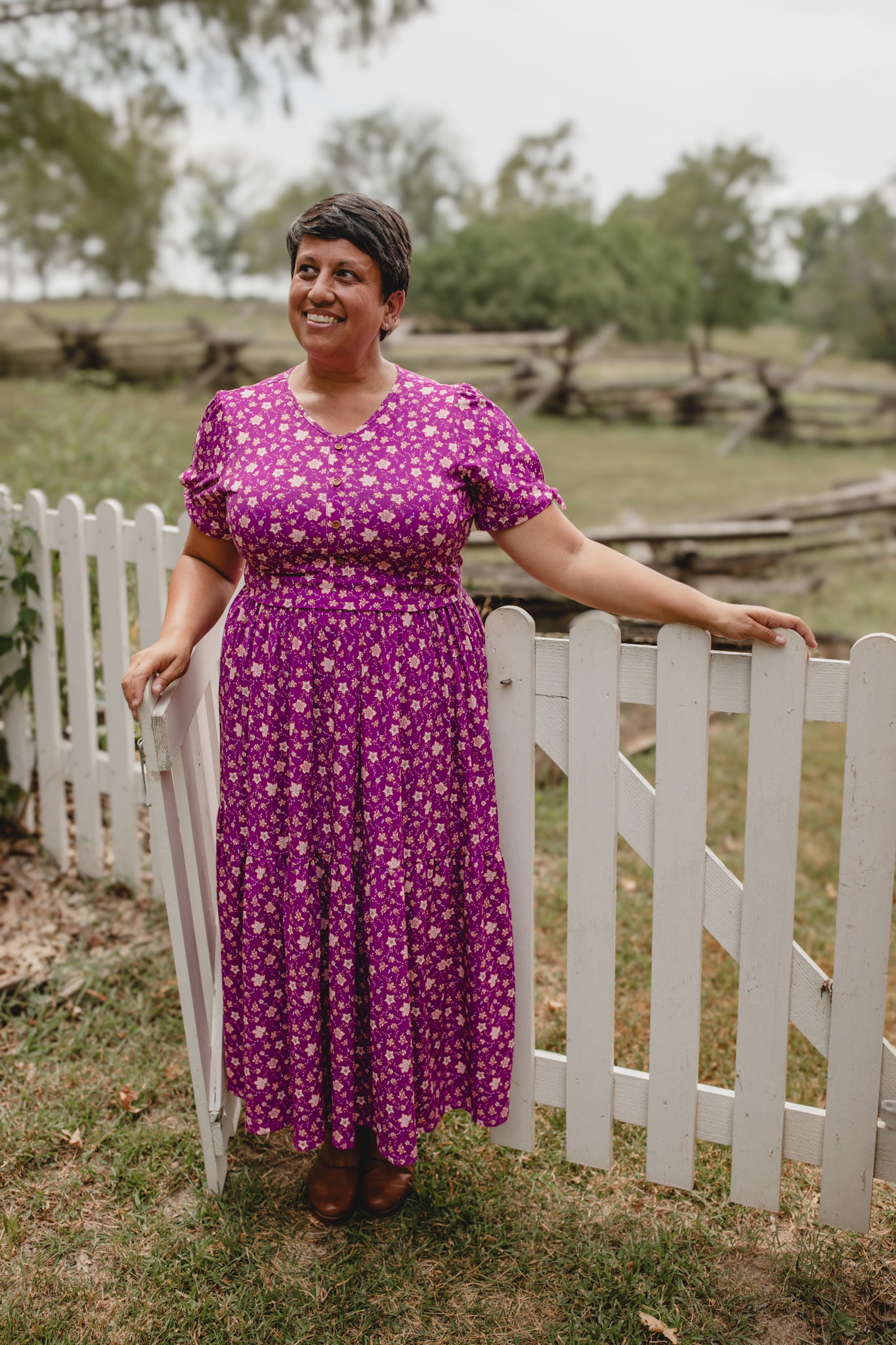 Woman in modest nursing dress by white fence