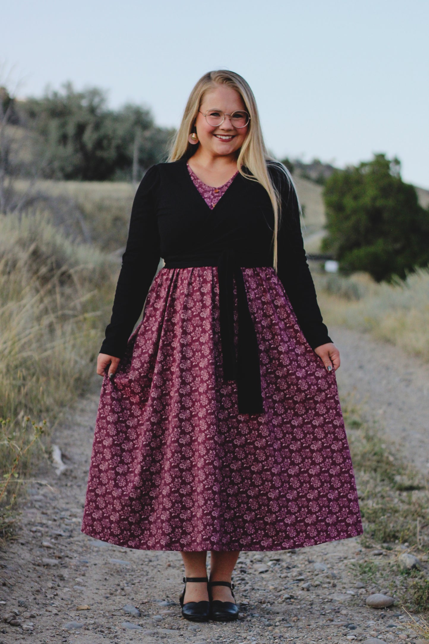 Woman in modest nursing-friendly black cardigan and purple floral dress