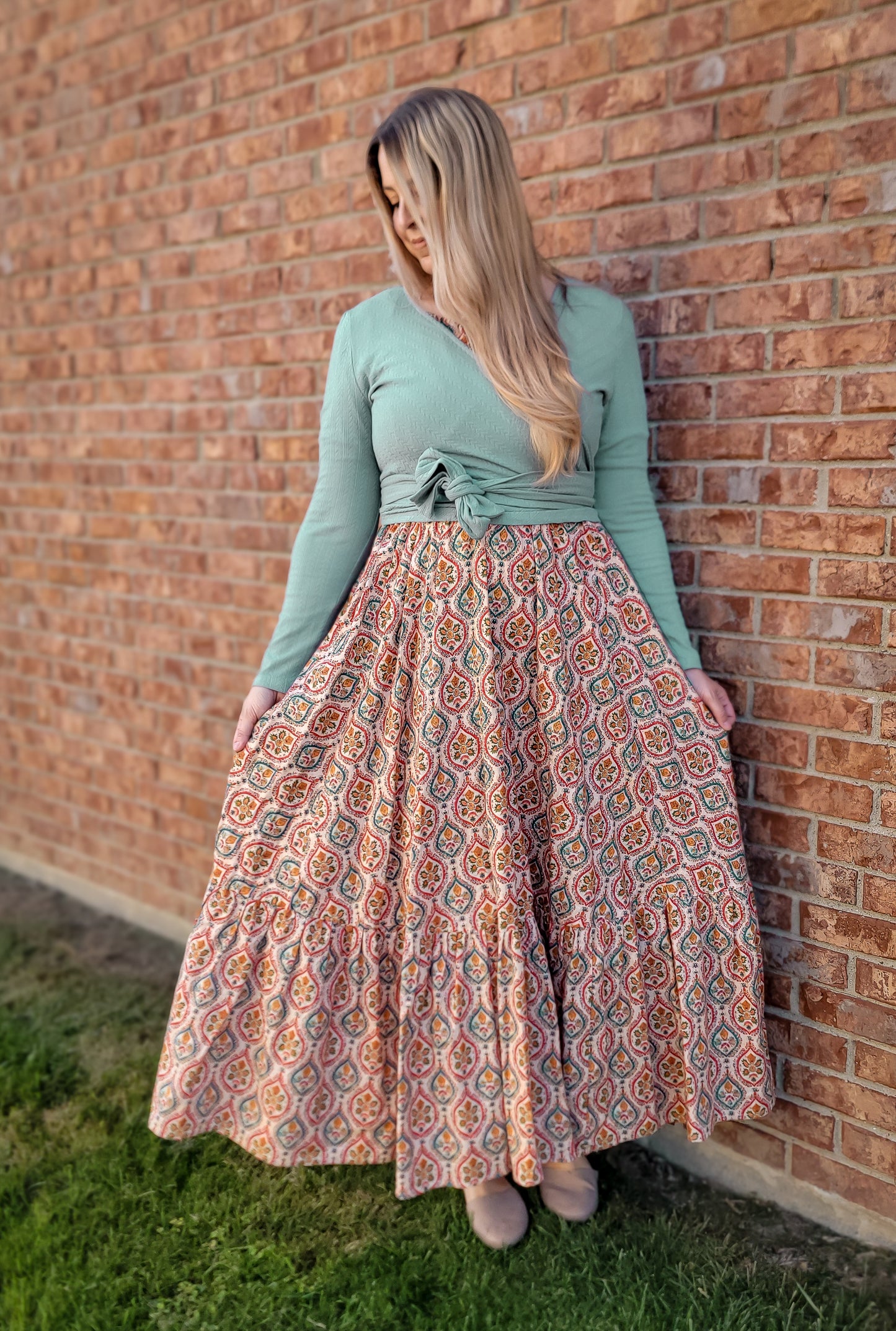 Woman in green top and patterned modest skirt