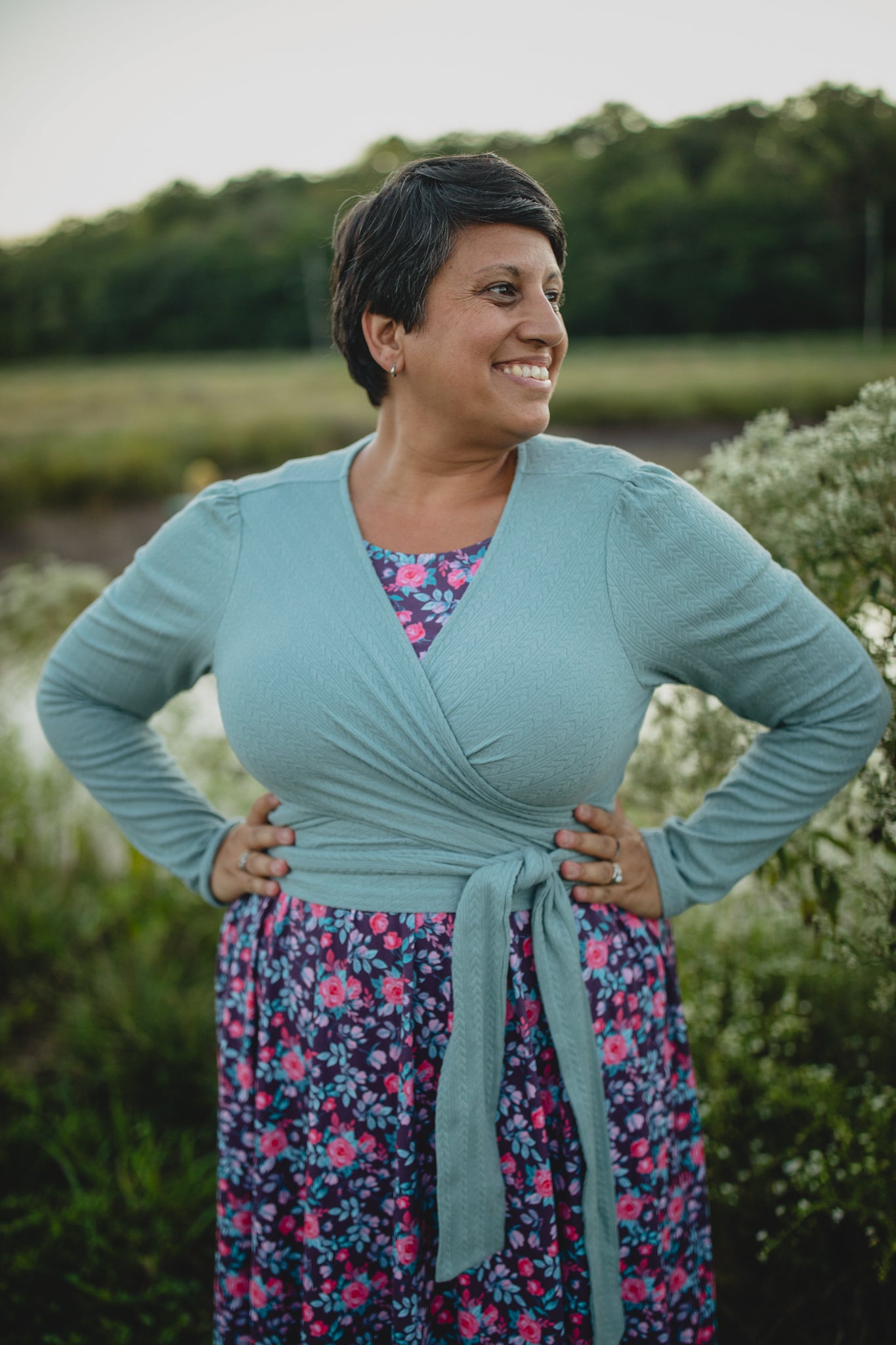 Woman in modest nursing wrap over floral dress