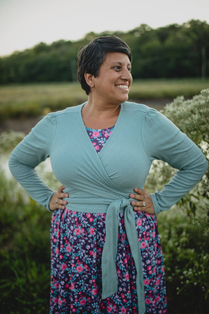 Woman in modest nursing wrap over floral dress