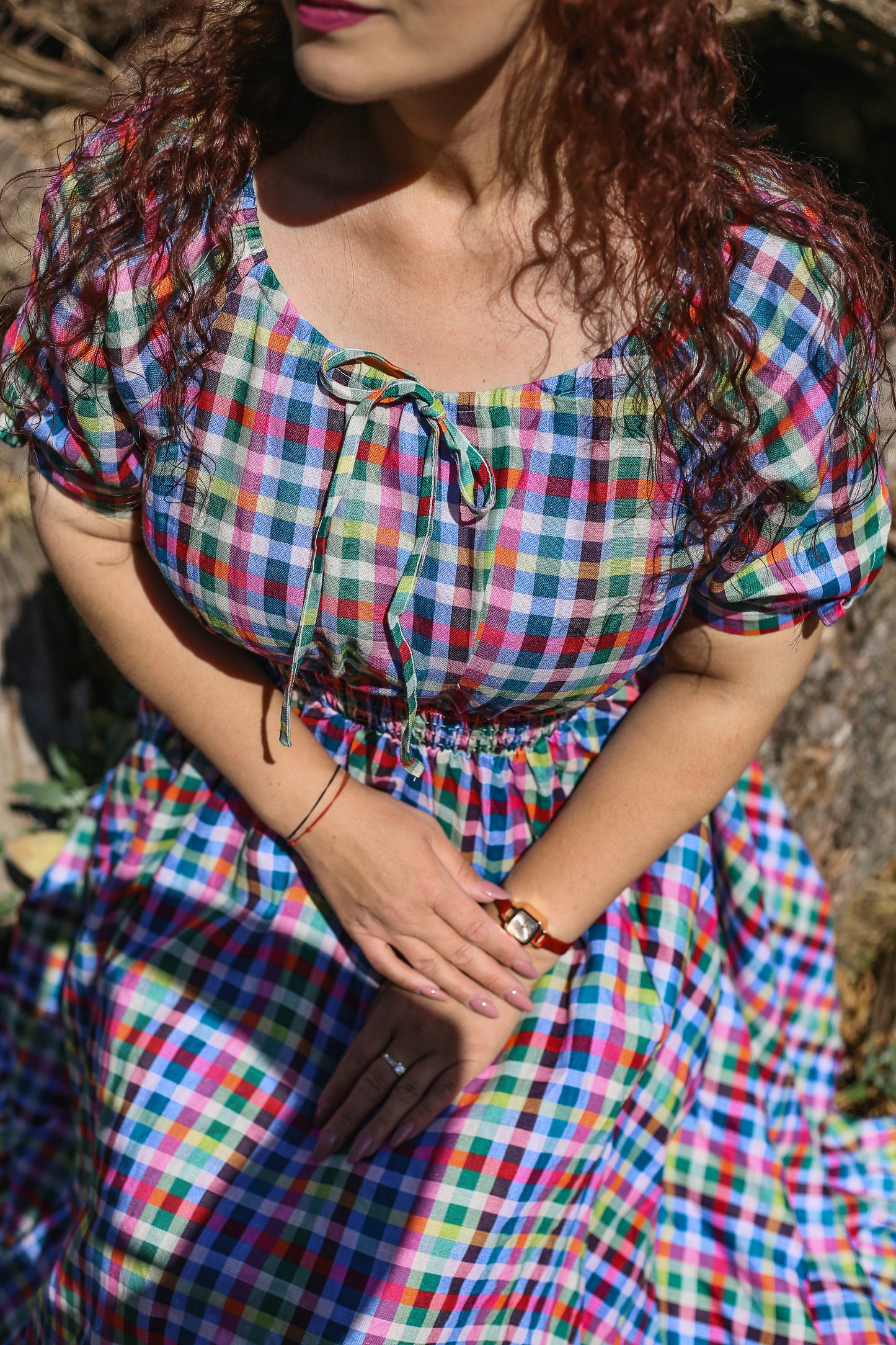 Woman wearing a colorful checkered modest nursing dress with a blurred background