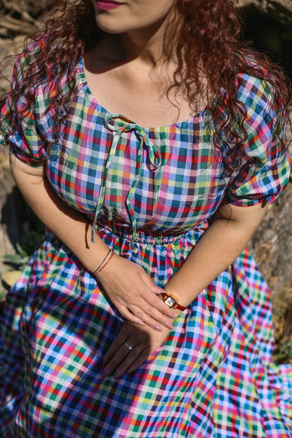 Woman wearing a colorful checkered modest nursing dress with a blurred background