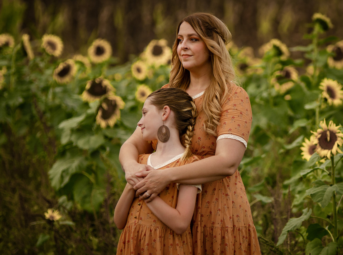 Woman in modest nursing dress in field with her daughter