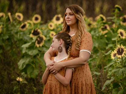 Woman in modest nursing dress in field with her daughter