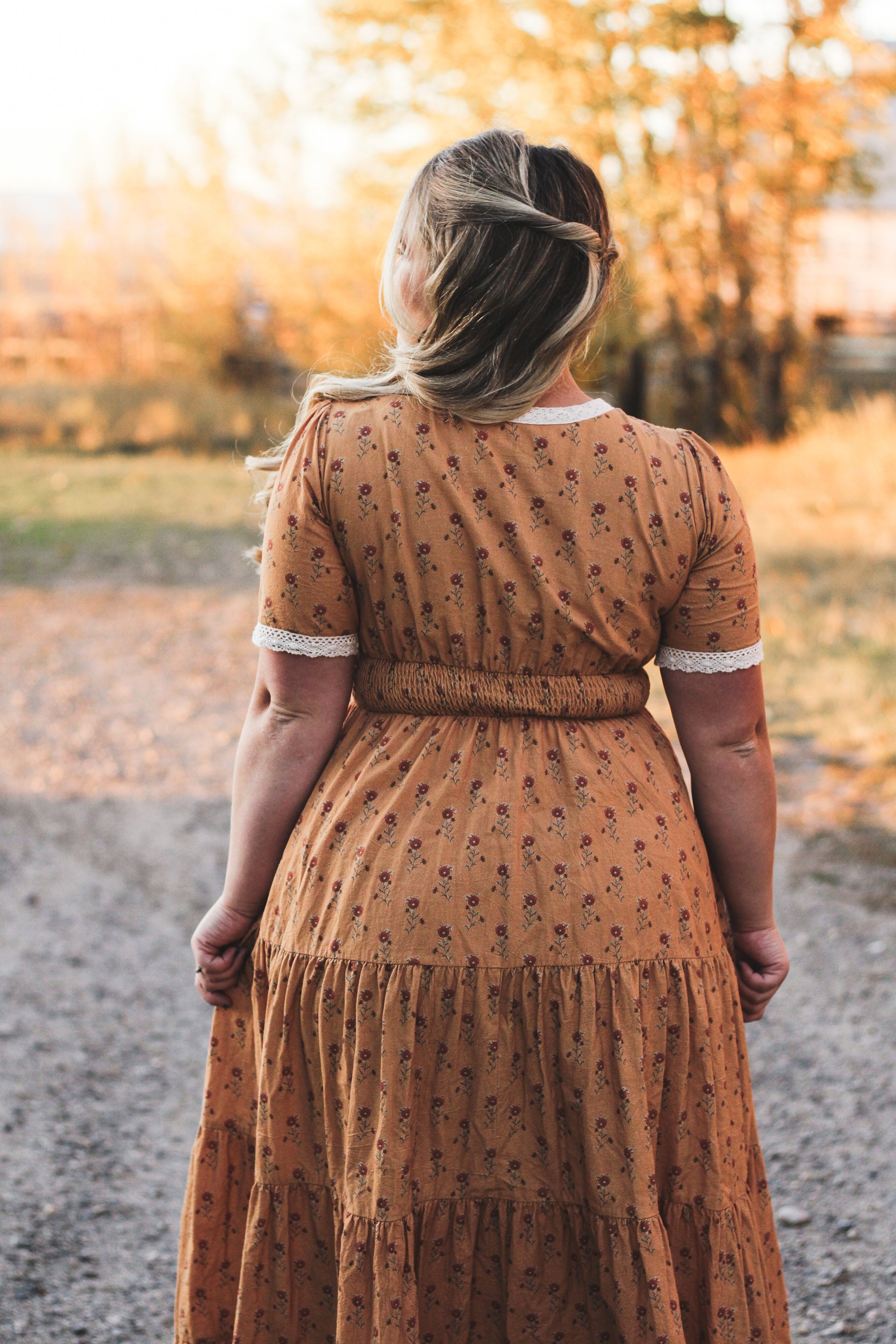 Woman in modest nursing dress outdoors with trees