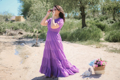 A woman wearing a purple, gingham, five-tiered maxi modest nursing dress