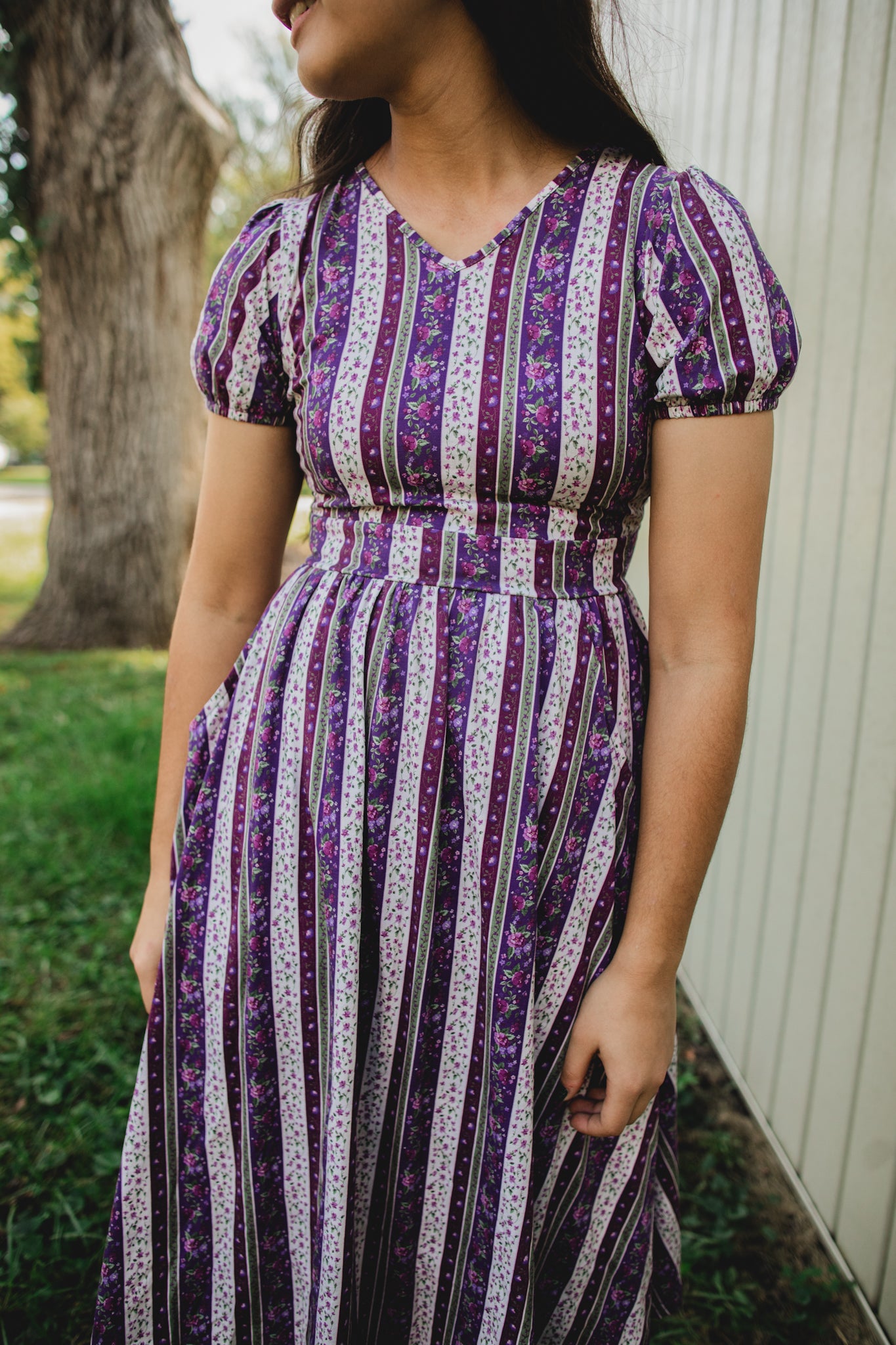 woman wearing a modest nursing purple and white striped dress