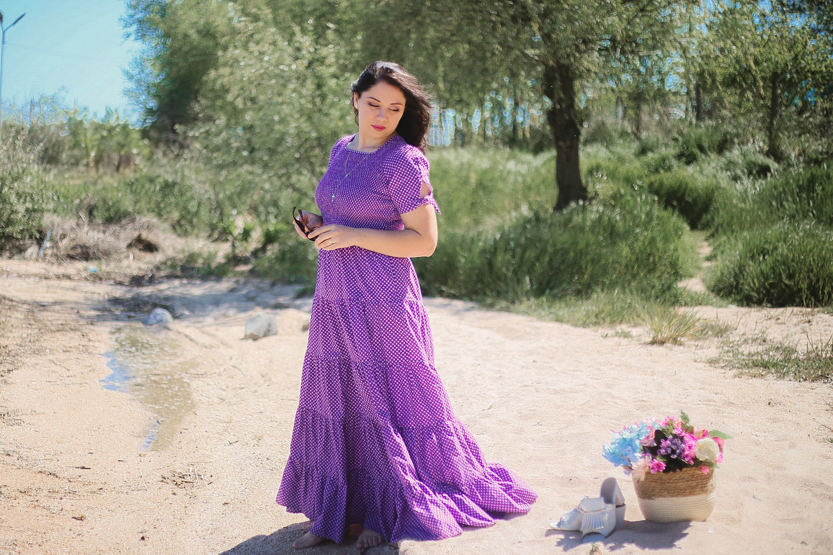 A woman wearing a purple, gingham, five-tiered maxi modest nursing dress