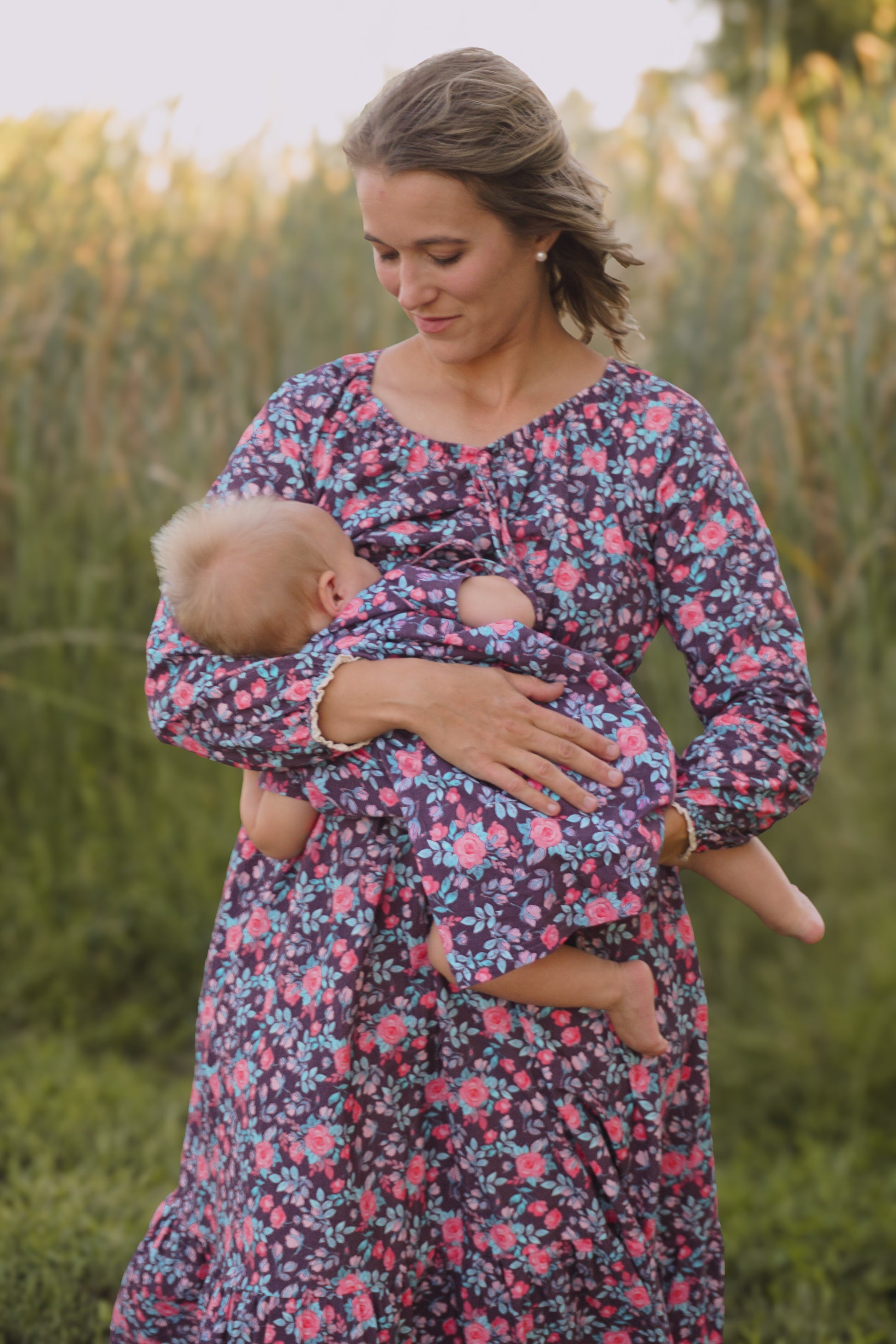Woman in modest nursing floral dress holding baby
