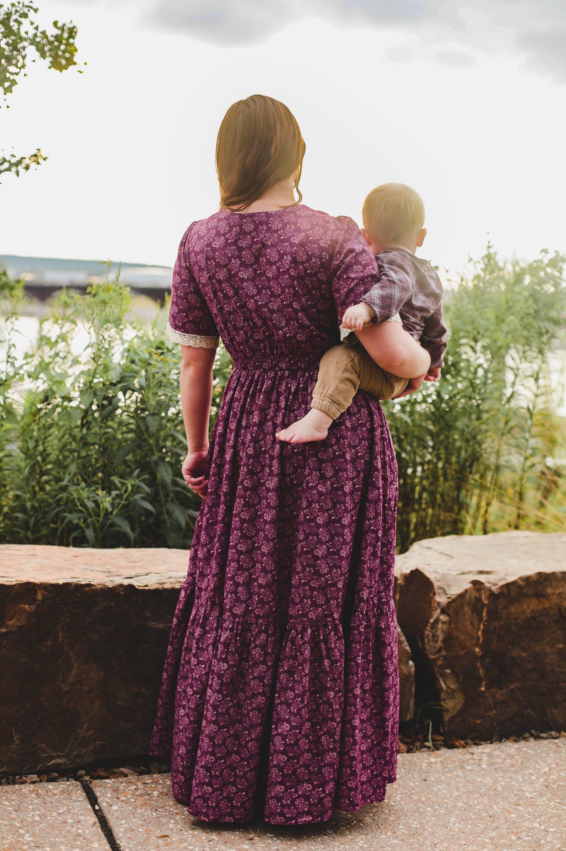 Woman in modest floral nursing dress with her child