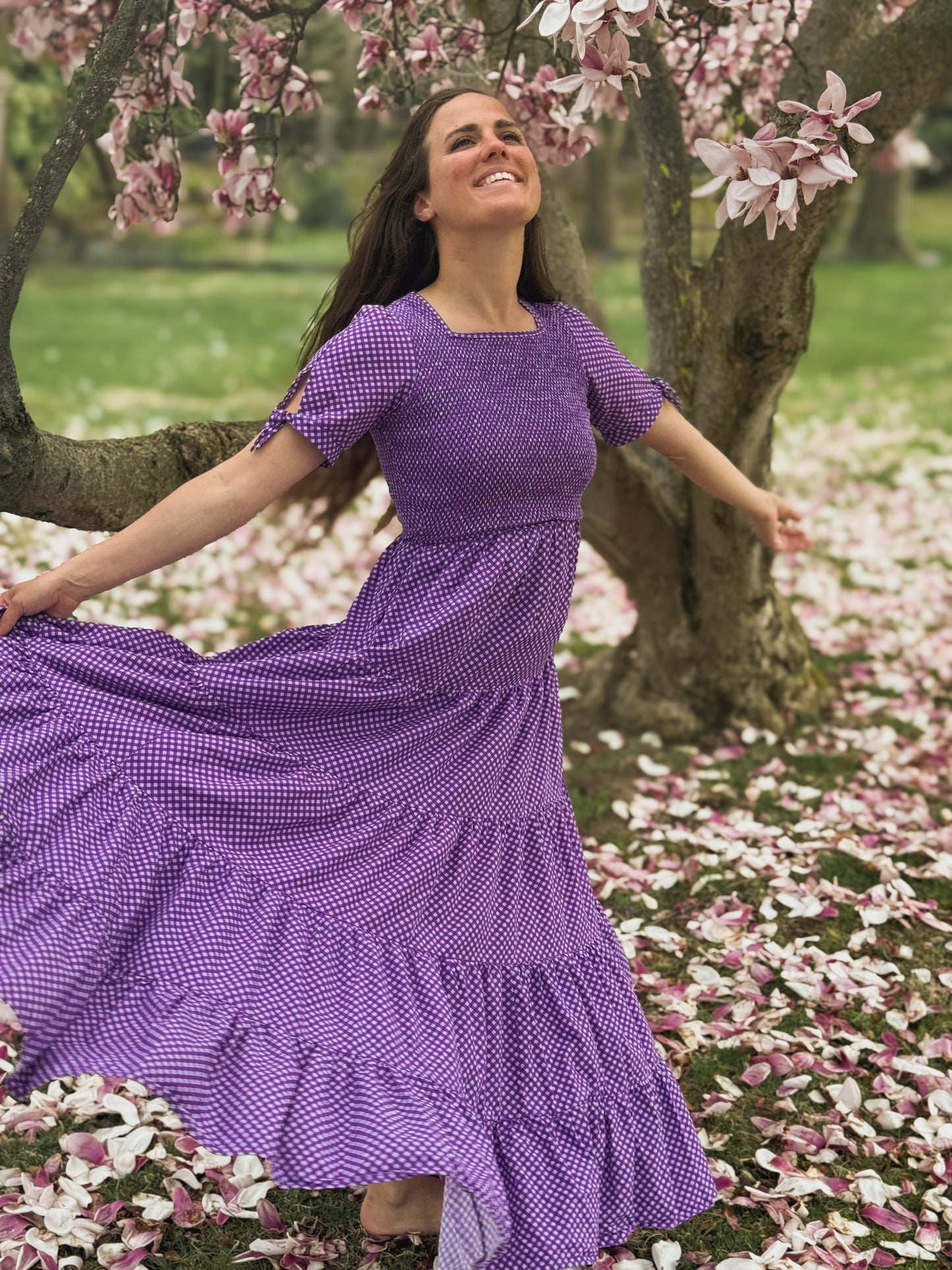 A woman wearing a purple, gingham, five-tiered maxi modest nursing dress