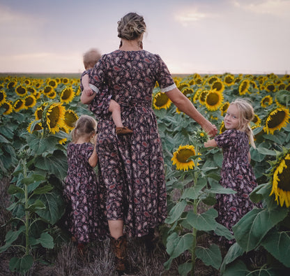 woman wearing a modest nursing black patterned dress with her daughters