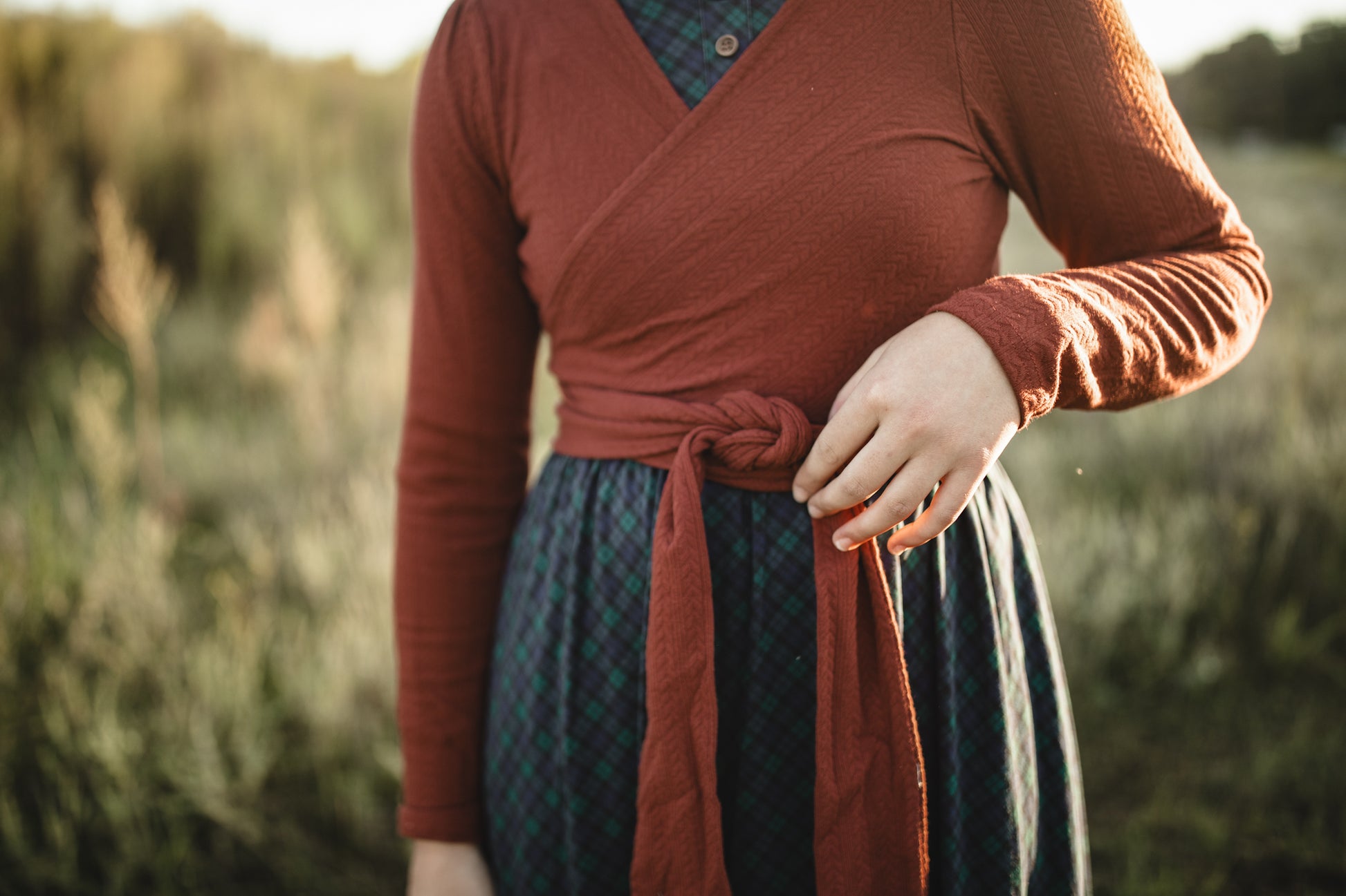 Woman in modest nursing rust plaid wrap dress