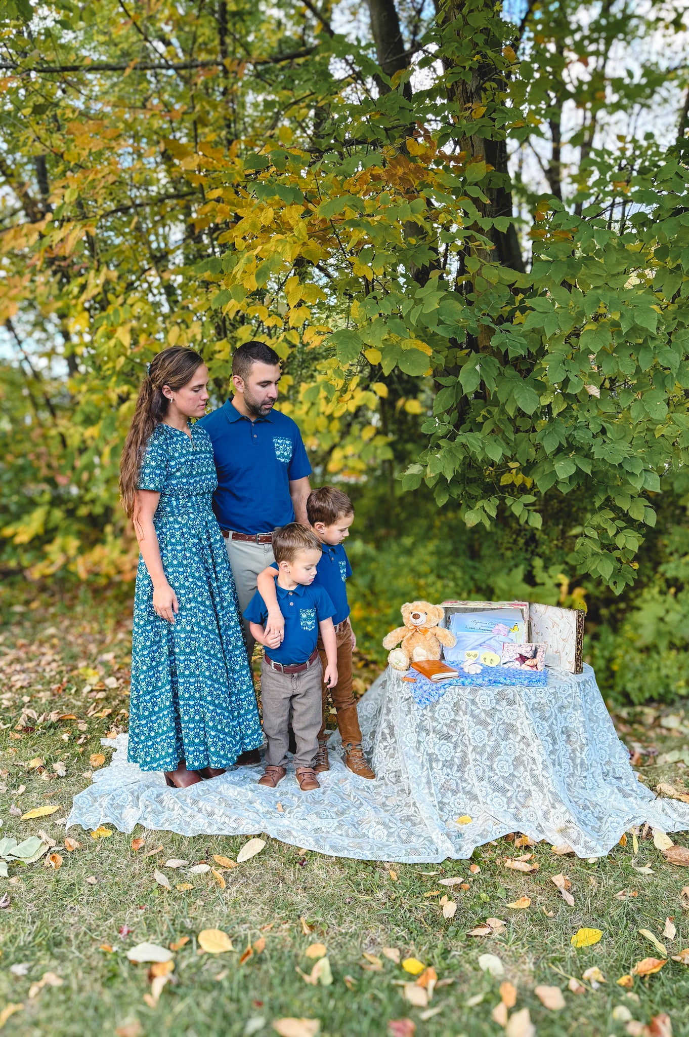 Modest nursing mother with family and baby outdoors