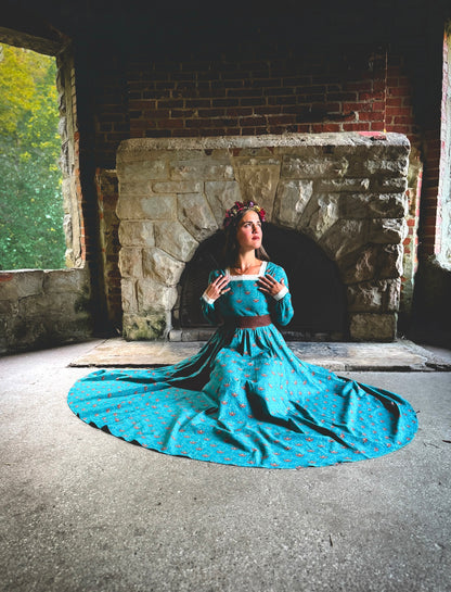 Woman in modest nursing blue dress by fireplace