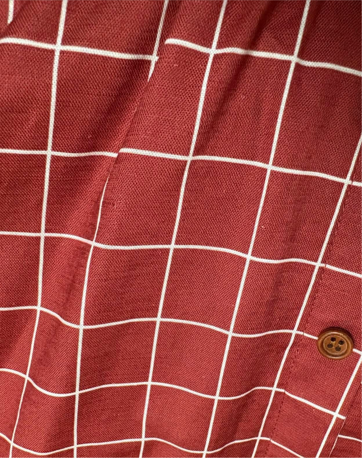 Red checkered fabric with a button on a red background