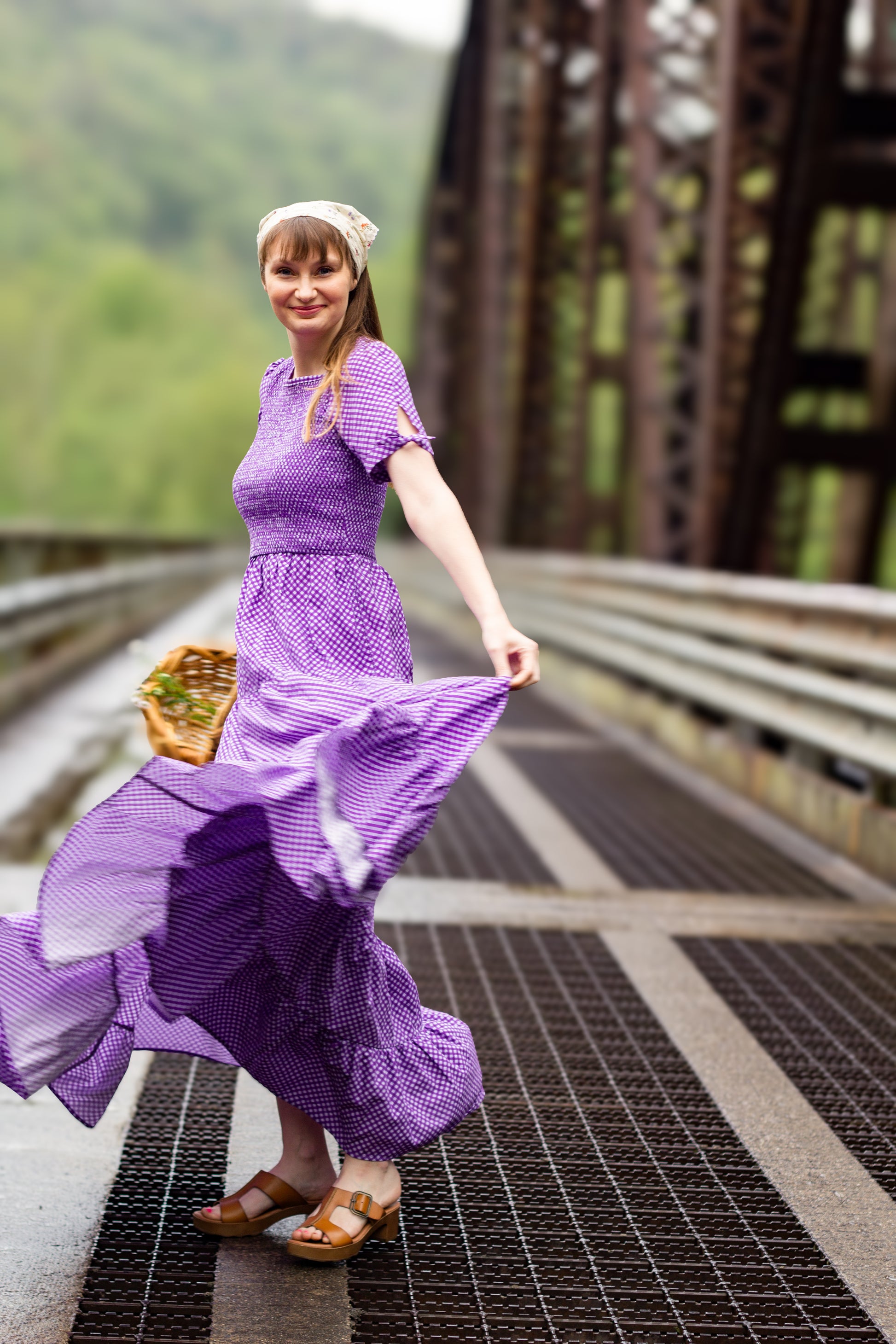 A woman wearing a purple, gingham, five-tiered maxi modest nursing dress