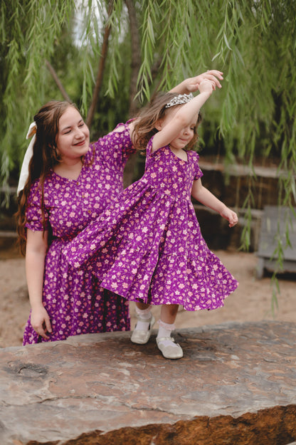 Two children in dresses on rock outdoors