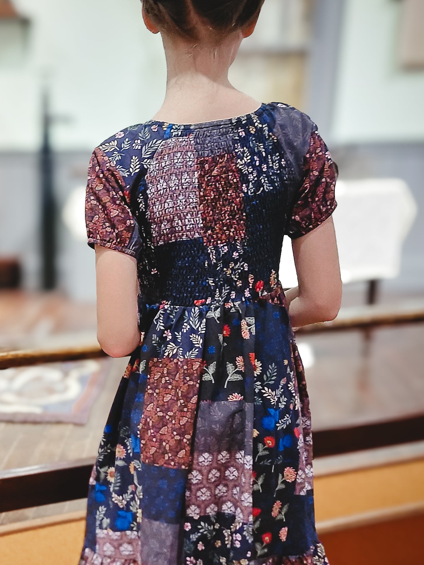 young girl wearing a cute patchwork dress