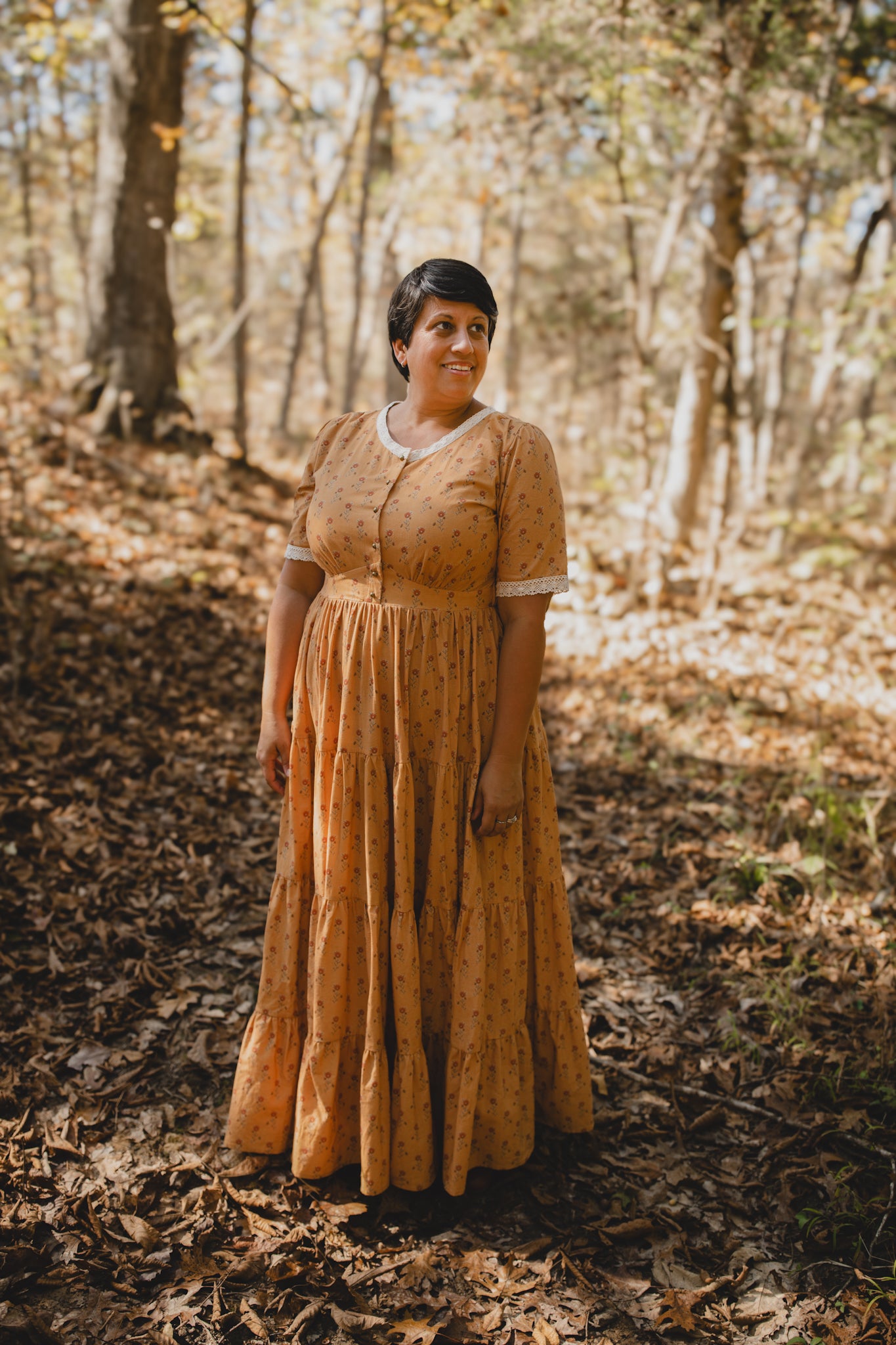 Woman in modest nursing dress forest autumn leaves