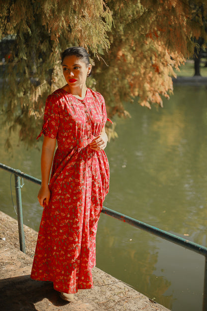 Woman in modest nursing red dress by water