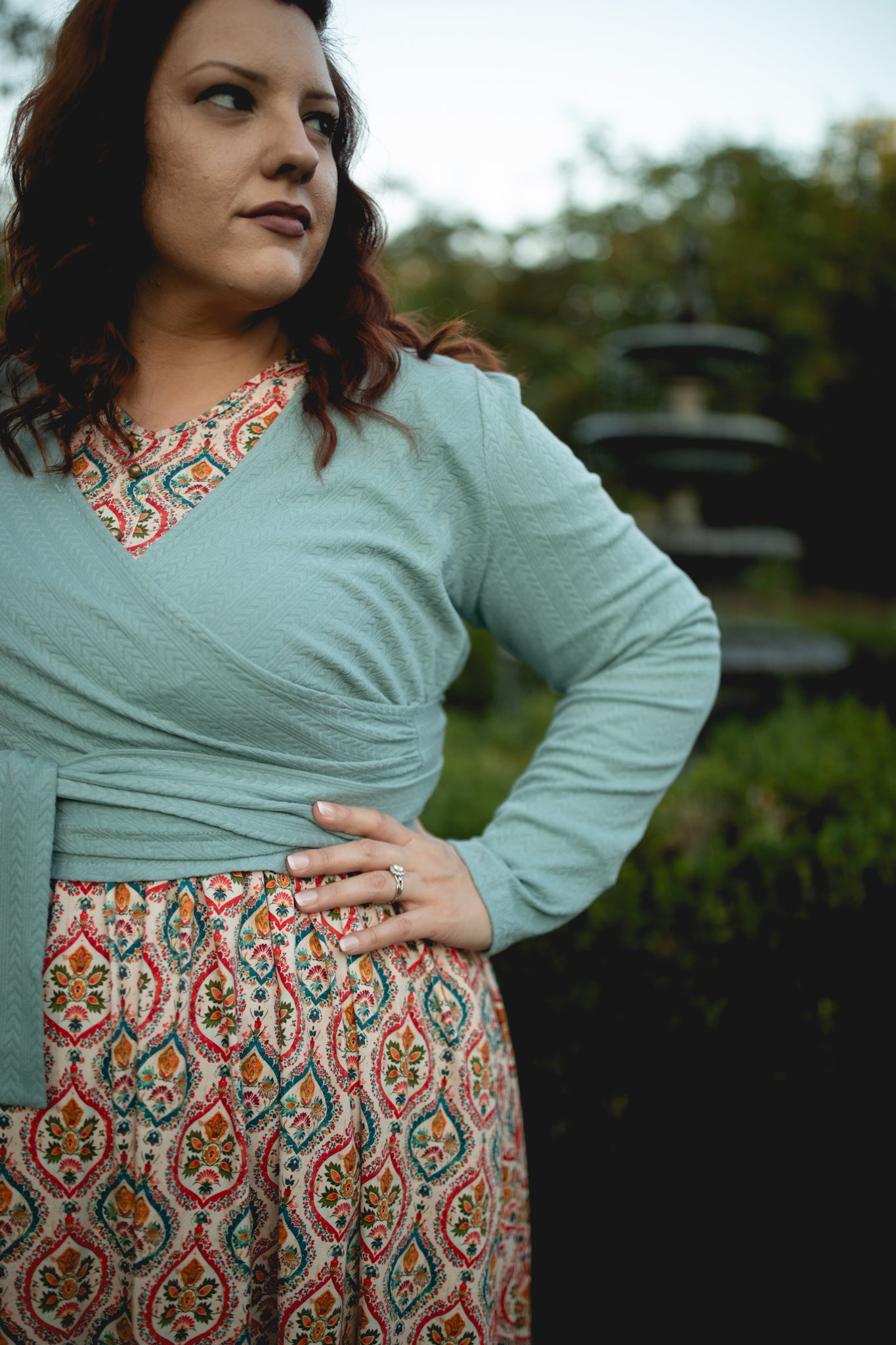 Woman in blue cardigan and patterned skirt