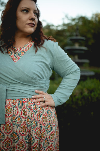 Woman in blue cardigan and patterned skirt