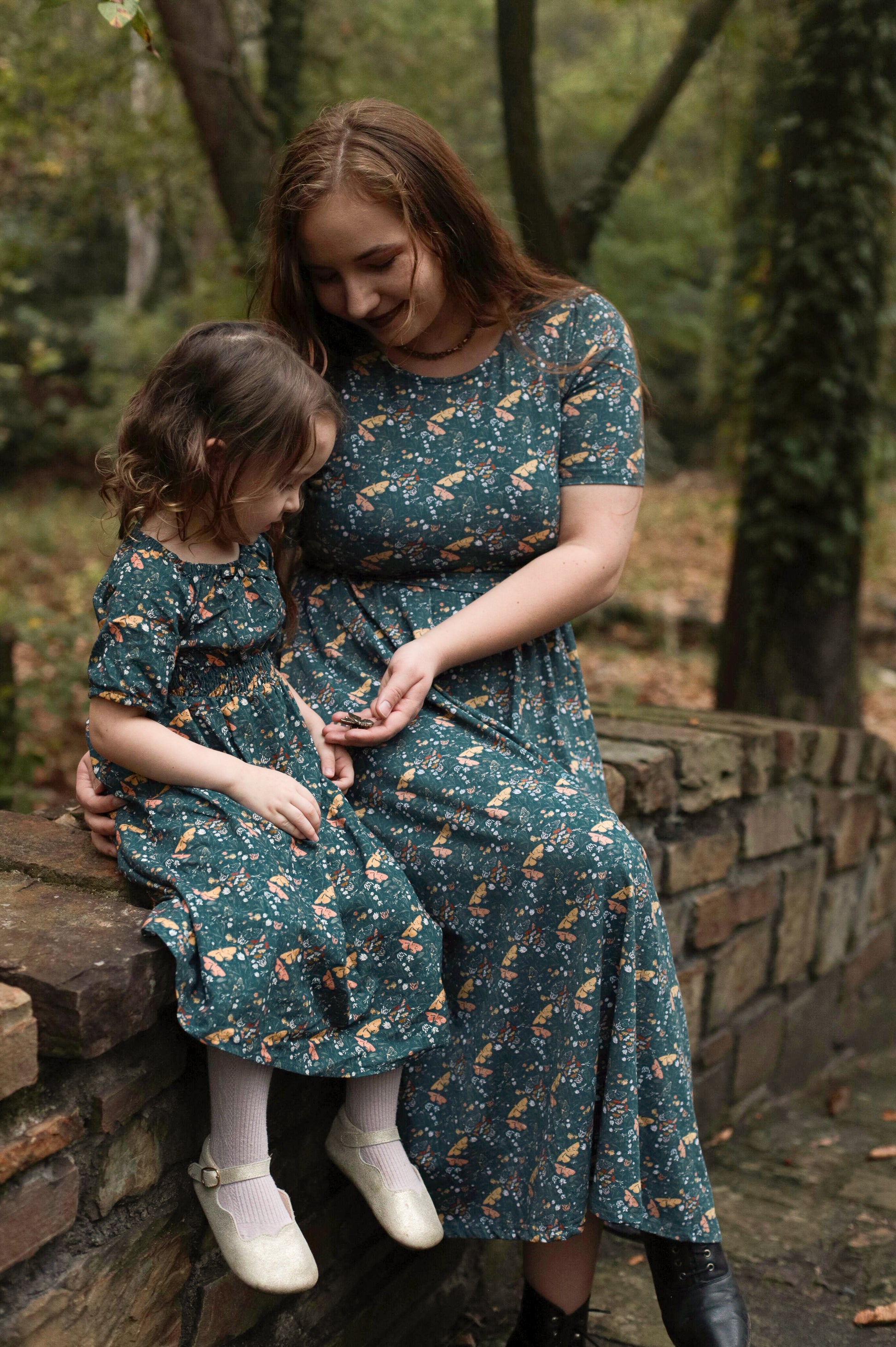 Woman in modest nursing dress with child outdoors