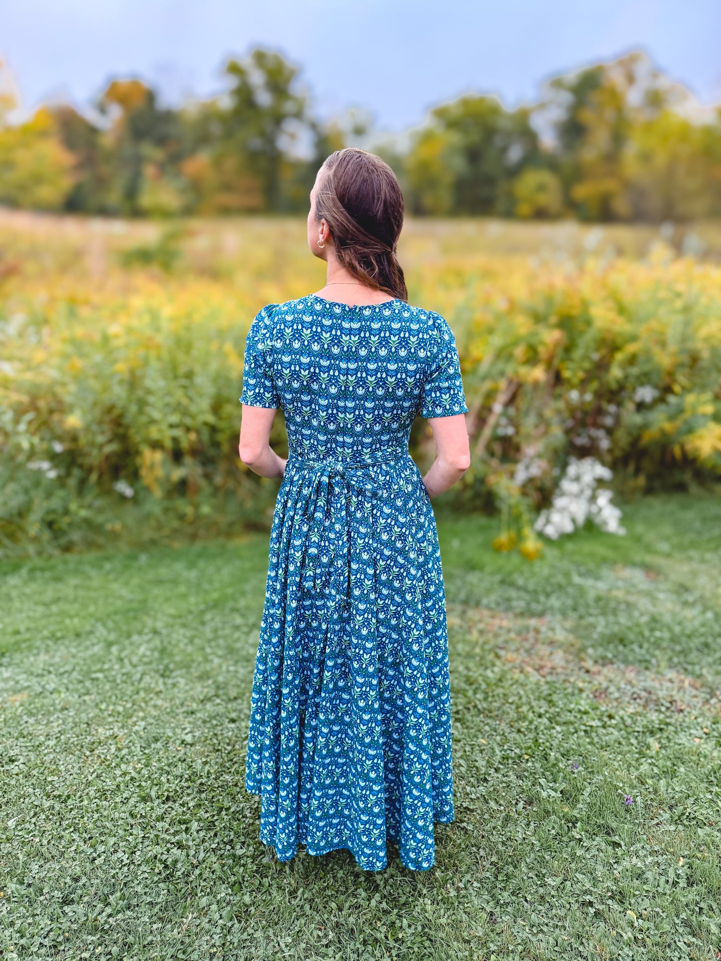Woman in modest nursing dress in field