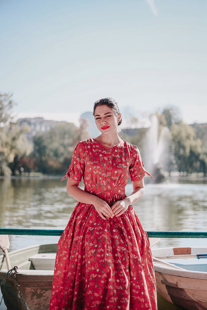 Woman in modest nursing red dress by lake