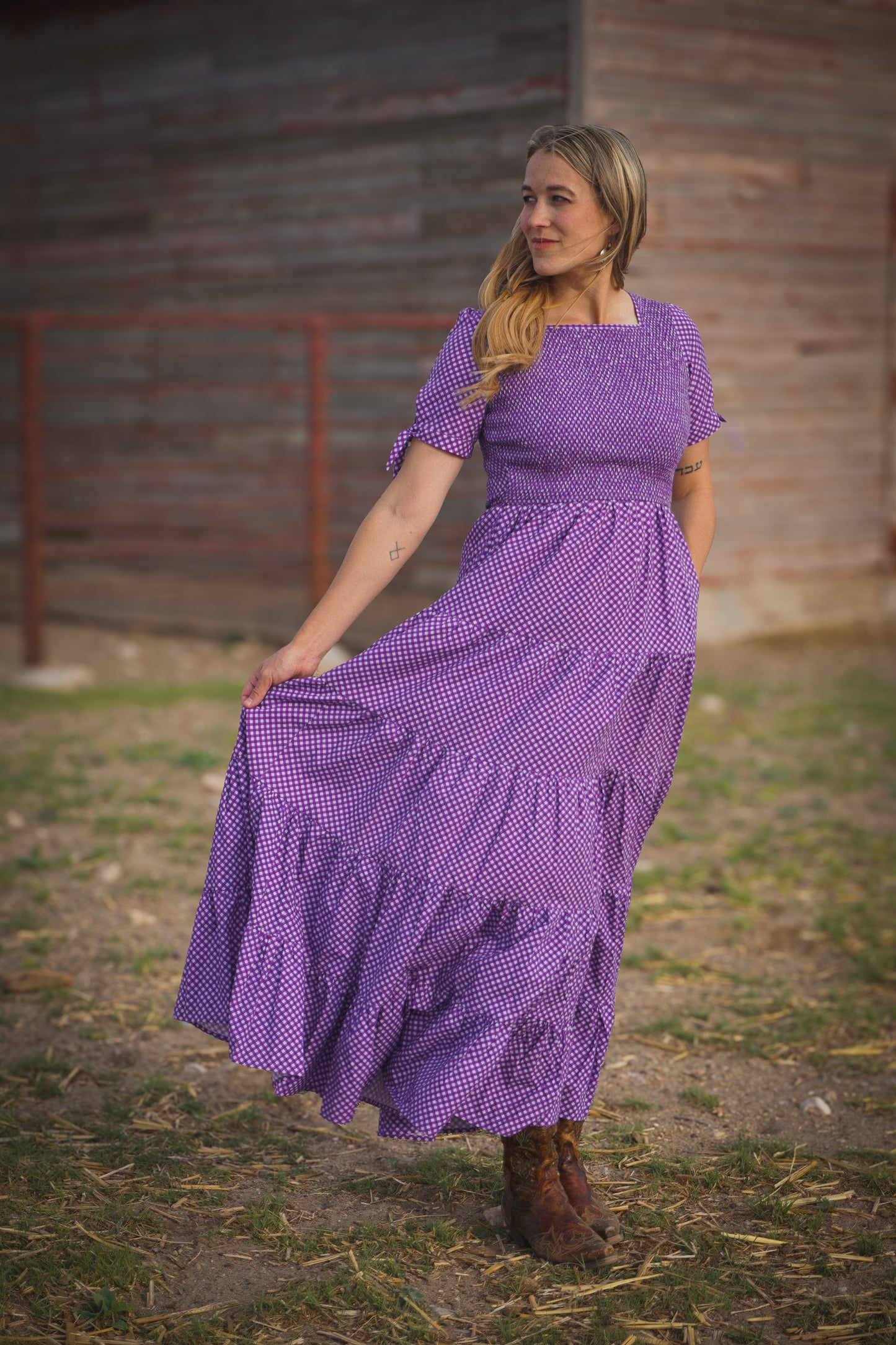 A woman wearing a purple, gingham, five-tiered maxi modest nursing dress