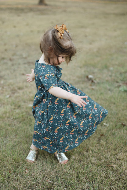Child in modest dress twirling outdoors