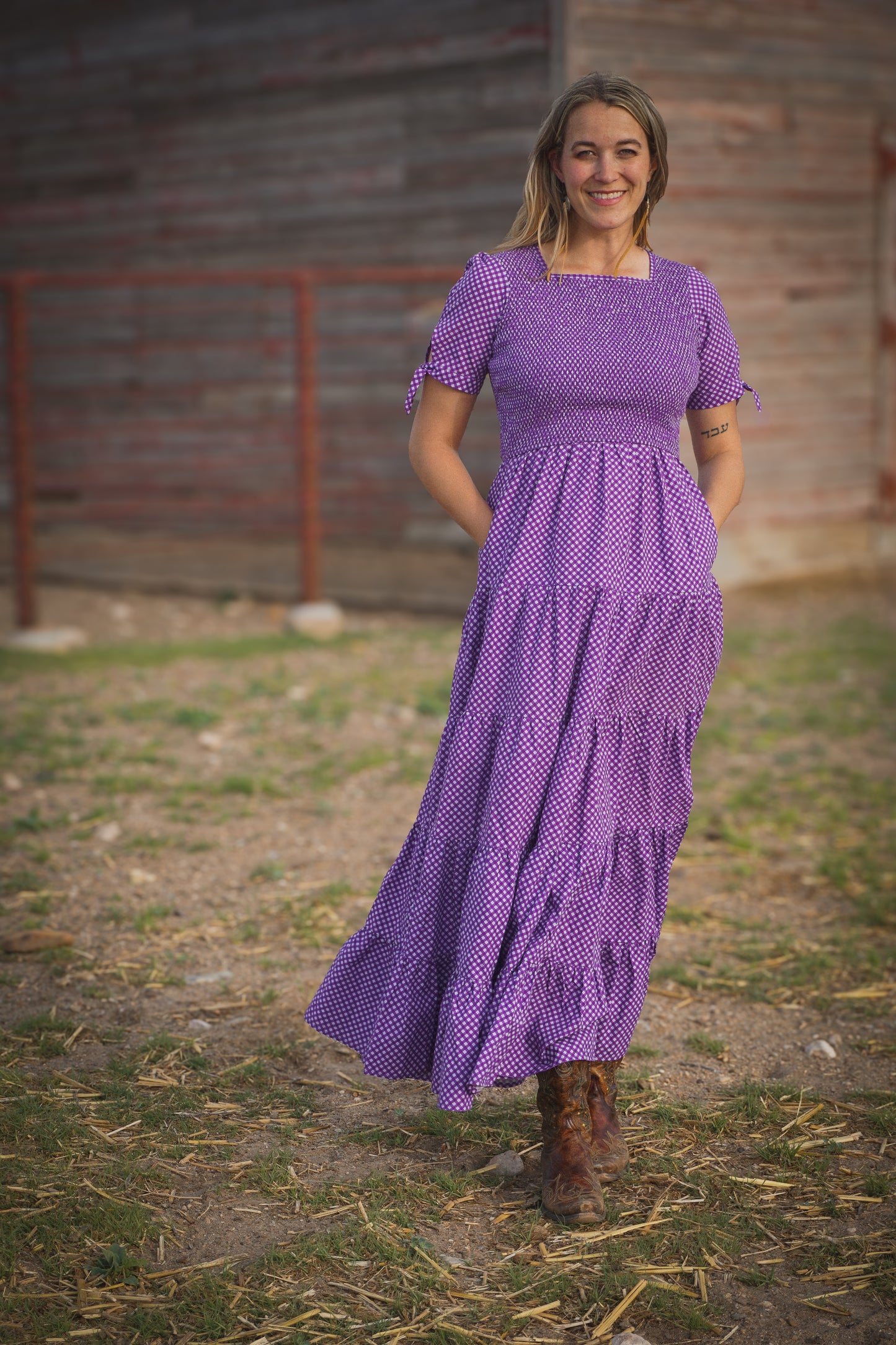 A woman wearing a purple, gingham, five-tiered maxi modest nursing dress